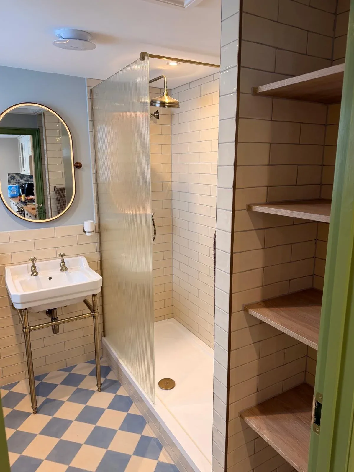 Completed bathroom with brass fittings, walk-in shower and checkered floor