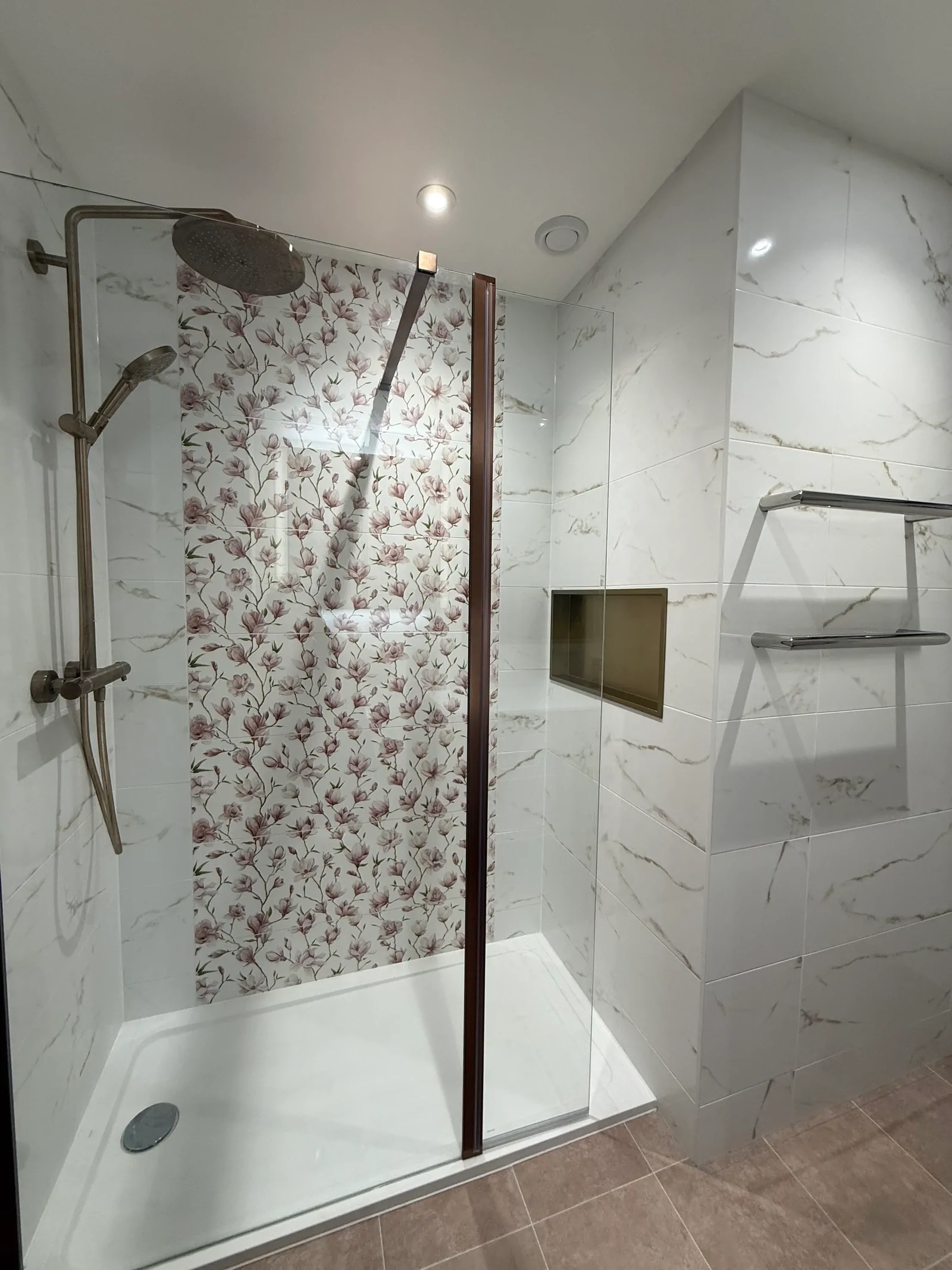Modern bathroom with white veined tiles, black shower and black taps
